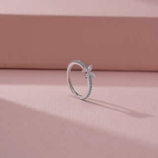 Angled view of a 14KT White Gold diamond ring featuring a butterfly motif with marquise diamonds and blue diamond accents.