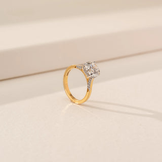 Angled view of Radiant Rounded Solitaire Ring in 14KT Yellow Gold, featuring a round lab-grown diamond against a beige backdrop.