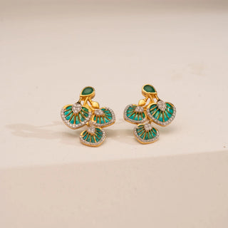 Top-down view of Reia’s 14 KT Yellow Gold Green Meenakari Floral Diamond Earrings. The layout highlights the intricate green enamel work and pavé-set round diamonds against a clean, cream backdrop.