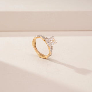 Angled view of a 14KT Yellow Gold diamond ring, featuring an emerald-cut centre diamond and diamond-set split shoulders.