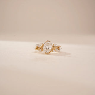 Front view of a 14KT Yellow Gold diamond ring, featuring an oval centre diamond and floral diamond-set shoulders.