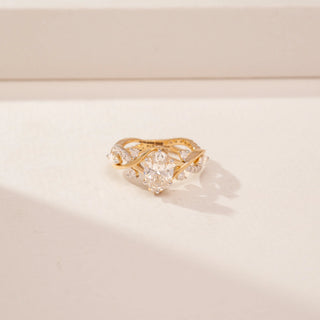 Top view of a 14KT Yellow Gold diamond ring, featuring an oval centre diamond and floral diamond-set shoulders.