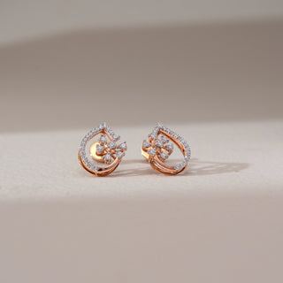 Front view of floral diamond drop earrings in rose gold, featuring round lab-grown diamonds in a blooming cluster within a teardrop frame lined with diamonds. Set on a soft neutral backdrop, they reflect graceful sparkle.