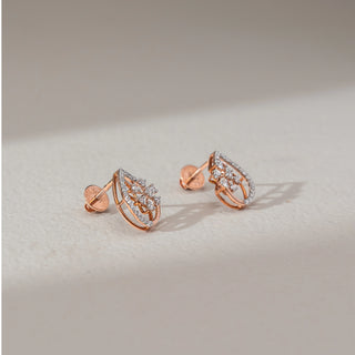 Side angled view of floral diamond drop earrings in rose gold, showing screw backs and round lab-grown diamonds in a cluster within a teardrop frame. Set on a soft neutral surface, they highlight structure and finish.