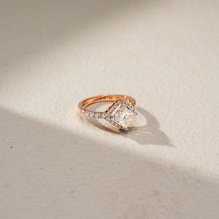 Side view of a princess halo engagement ring in 14 KT White Gold, featuring a princess-cut lab-grown diamond framed by a sparkling halo and accented by a diamond-set band, displayed against a beige backdrop.