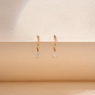 Front view of pear-shaped lab-grown diamond drop hoop earrings in 14 KT yellow gold, featuring sleek polished hoops with delicate pear-cut diamond drop charms in a timeless minimalist design.