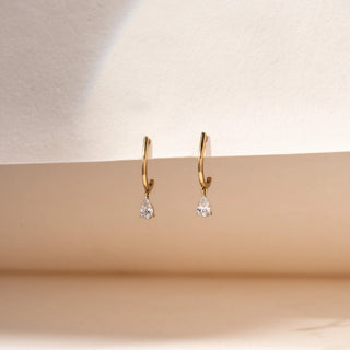 Side view of pear-shaped lab-grown diamond drop hoop earrings in 14 KT white gold, featuring sleek polished hoops with delicate pear-cut diamond drop charms in a timeless minimalist design.