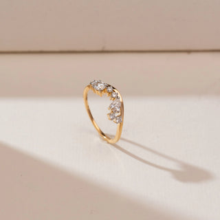 Angled view of Curved Tiara Crown Diamond Band in yellow gold, showcasing a pear-shaped lab-grown diamond with graduated round diamond accents forming a crown-inspired curved design on a beige backdrop.