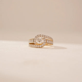 Close-up view of a 14KT Yellow Gold diamond ring, featuring a round centre diamond and diamond-set crossover bands.