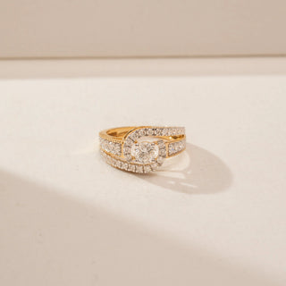Front view of a 14KT Yellow Gold diamond ring, featuring a round centre diamond and diamond-set crossover bands.