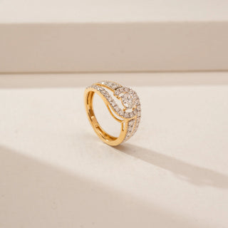 Angled view of a 14KT Yellow Gold diamond ring, featuring a round centre diamond and diamond-set crossover bands.