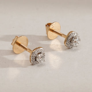 Close-up of a female Halo Solitaire Diamond Stud Earring crafted in yellow gold with a Bombay screw back. The 14KT hallmarked gold setting holds a central round solitaire diamond of 0.45 carats, EF colour and VVS clarity, surrounded by a halo of smaller diamonds, totalling 1.116 carats.