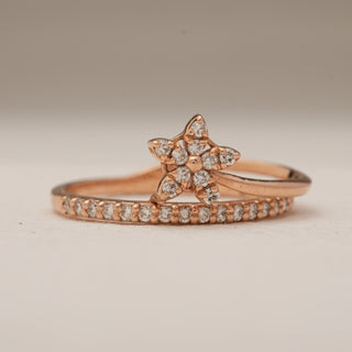 Front view of Starlight Charm Diamond Ring in rose gold, highlighting the five-petal star-shaped diamond cluster centerpiece and a slim band lined with EF VVS lab grown diamonds, photographed on a plain beige background.