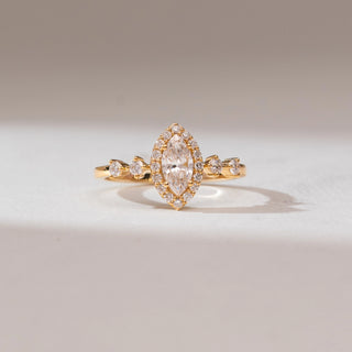 Front view of 14KT yellow gold ring featuring a marquise-cut centre diamond encircled by a halo of round diamonds, with pear-shaped side stones along the band.