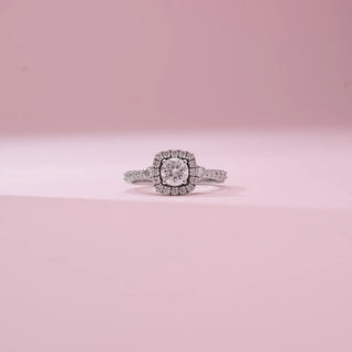 Front view of Reia’s 14 KT White Gold Eternal Grace Halo Solitaire Diamond Ring, showing the centred solitaire and diamond halo. Set against pink, it highlights refined, elegant sparkle.
