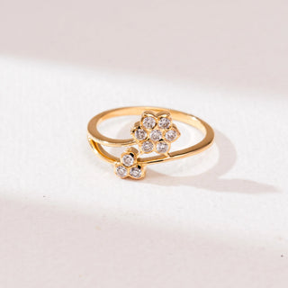 Front view of Dual Floral Cluster Diamond Ring in 14KT Yellow Gold, featuring a larger six-diamond flower and a smaller three-diamond bud on an open bypass band, set against a soft neutral backdrop.