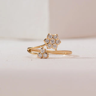 Front view of Dual Floral Cluster Diamond Ring in 14KT Yellow Gold, featuring a six-diamond flower and a three-diamond bud on an open bypass band, set against a soft neutral backdrop.