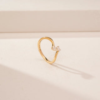 Angled view of a 14KT Yellow Gold diamond ring, featuring emerald and pear-shaped diamonds on a curved band.