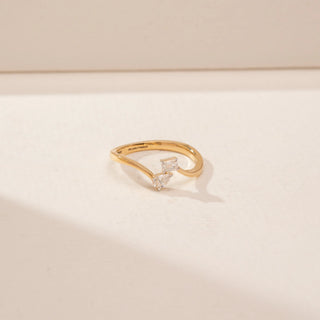 Top view of a 14KT Yellow Gold diamond ring, featuring emerald and pear-shaped diamonds on a curved band.