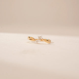 Front view of a 14KT Yellow Gold diamond ring, featuring emerald and pear-shaped diamonds on a curved band.