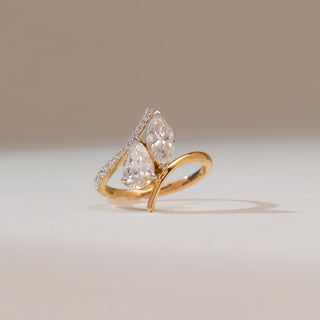 Front view of 14KT yellow gold bypass ring featuring marquise and pear-shaped diamonds with pavé-set accents along the curved band.