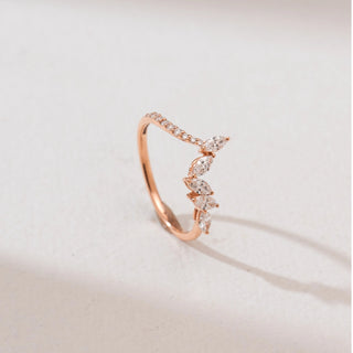 Side view of a 14KT rose gold marquise chevron diamond ring with marquise-cut diamonds arranged in a V-shaped design and a delicate pavé-set band, displayed on a soft neutral background.