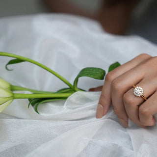 Floral cluster ring featuring round-cut diamonds arranged in a bloom design, set on a slim polished band for a bright and elegant look.
