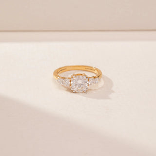 Close_up view of a 14KT Yellow Gold diamond ring, featuring a round centre diamond and diamond-set side stones.