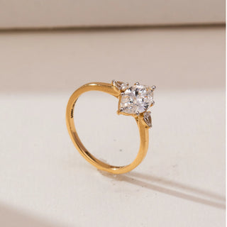 Angled view of Marquise Pear Trio Diamond Ring in yellow gold, showcasing a marquise-cut lab-grown diamond with pear-shaped side accents, displayed on a soft beige backdrop.