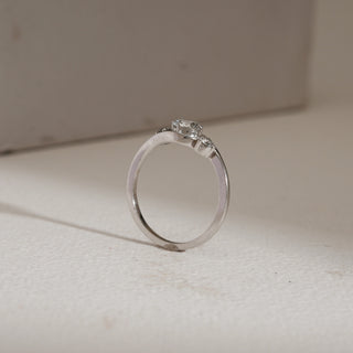 Side view of Asymmetrical Three-Stone Diamond Engagement Ring photographed on beige background. Made in 14KT hallmarked white gold, size 12, with EF VVS lab grown diamonds weighing 0.65 carats total, including solitaire of 0.51 carats. Ring weighs 2.15 grams, priced INR 15,000–50,000.