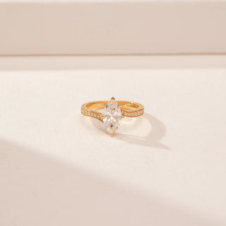Close-up view of a 14KT Yellow Gold diamond ring, featuring marquise-cut diamond and a diamond-set curved band.