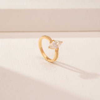 Angled view of a 14KT Yellow Gold diamond ring, featuring marquise-cut diamond and a diamond-set curved band.