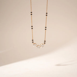 Front view of 14KT Yellow Gold diamond mangalsutra featuring three round diamonds and black bead accents along the chain.