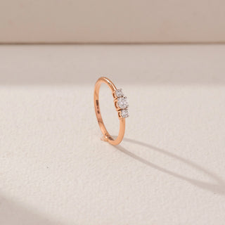 Angled view of Trio Diamond Ring in 14KT Rose Gold, featuring a round centre lab-grown diamond with two round side stones.