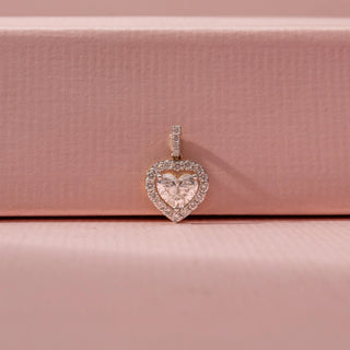 Front view of a 14KT white gold pendant featuring heart and round-cut diamonds in a double-heart design, set against a pink background.