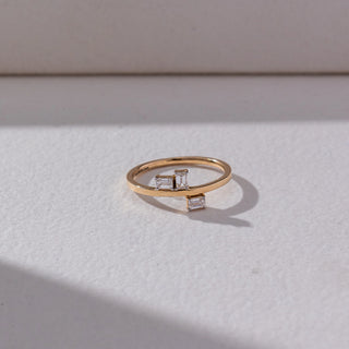 Top view of Baguette Diamond Open Ring in 14KT Yellow Gold, featuring two baguette-cut lab grown diamonds on an open band. Set on a beige backdrop, the design highlights clean lines and modern elegance.
