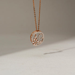Side view of a rose gold floral circle pendant necklace with pavé-set diamonds and marquise-cut stones, suspended from a delicate chain against a soft neutral background.