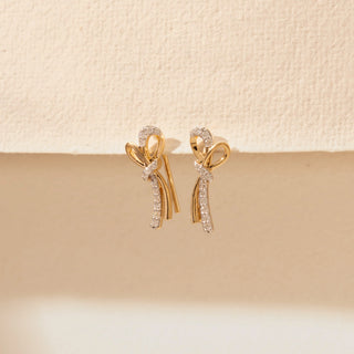 Close-up view of Bow Drop Diamond Earrings in 14KT Yellow Gold, featuring looped bow motifs and pavé diamond drops.