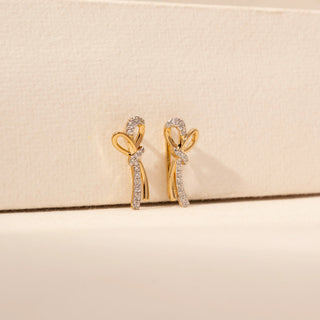 Side view of Bow Drop Diamond Earrings in 14KT Yellow Gold, featuring looped bow motifs and pavé diamond drops.