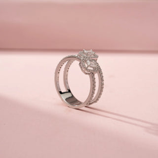 Side view of a double halo wrap ring in White Gold, featuring two emerald-cut lab-grown diamonds framed by sparkling halo settings on an open-ended pavé-set band, displayed against a soft pink backdrop.