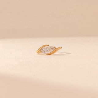 Front view of a 14KT yellow gold ring featuring a marquise-cut diamond in a bezel setting, set against a beige background.