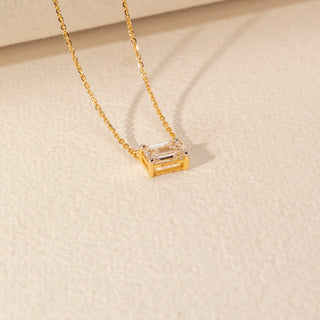 Angled view of Emerald-Cut Solitaire Diamond Pendant in 14KT Yellow Gold, featuring a bezel-set lab-grown diamond on a fine chain.
