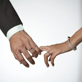 Close-up of a couple's hands where the woman wears Reia Sunlit Glow Radiant Diamond Ring, symbolising connection and warmth, featuring a yellow radiant-cut diamond set in white gold.