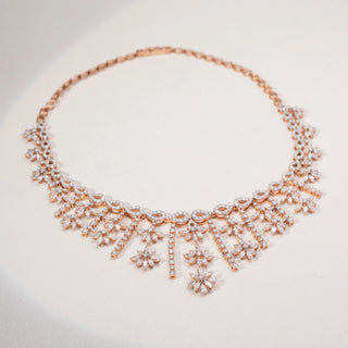 Top view of a floral lab-grown diamond necklace in 14KT Rose Gold, featuring cascading marquise and round diamond motifs with elegant drop details. Captured against a beige backdrop, the statement design radiates brilliance.