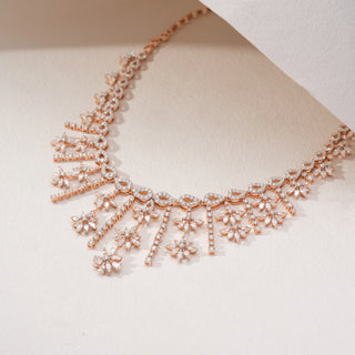 Angled view of a floral lab-grown diamond necklace in 14KT Rose Gold, featuring cascading marquise and round diamond motifs with elegant drop details. Captured against a beige backdrop, the statement design radiates brilliance.
