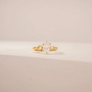 Front view of 14KT Yellow Gold ring featuring a oval-cut centre diamond, round diamond accents and a twisted band design.