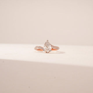 Front view of a 14KT Rose Gold diamond ring featuring a pear-cut centre diamond and a split pavé band.