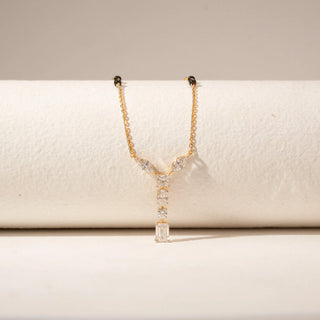 Close-up view of 14KT Yellow Gold mangalsutra with marquise, Emerald, princess and oval-cut diamonds in a Y-shaped pendant and black beads.
