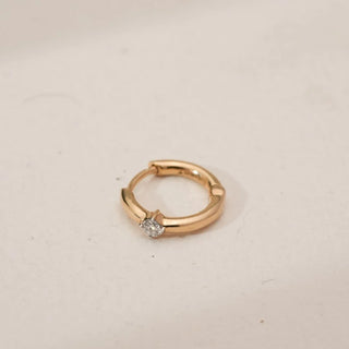 Top angled view of Minimalist Round Solitaire Diamond Nosepin in yellow gold, featuring a single round lab-grown diamond set in a classic solitaire mount on a neutral surface.