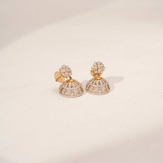 Side view of floral lab-grown diamond jhumka earrings in 18KT Yellow Gold, featuring marquise diamond flower studs with openwork dome drops. Captured against a beige backdrop, the intricate design radiates timeless elegance.